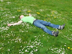 man lying on grass on his back to relax man lying on grass on his back to relax